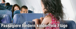 Kind steht in einem Flugzeug auf einem Sitz