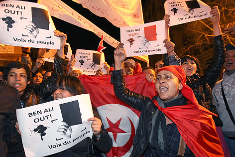 Demonstranten mit Schildern "Ben Ali Out"