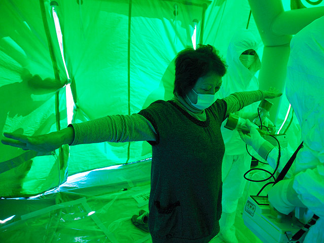 Frau lässt sich in grünem Zelt auf Strahlung testen