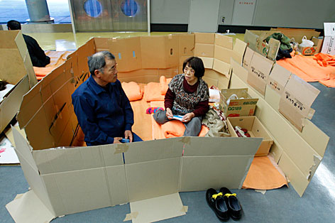 Zwei Japaner haben sich in einem Notlager durch das Aufstellen von Kartons eine "Privatsphäre" geschaffen