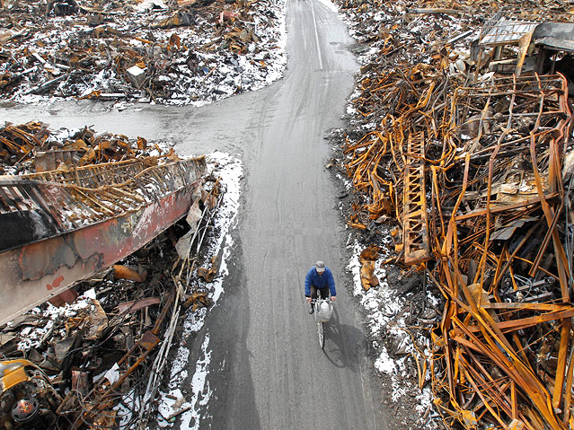 Ein Mann fährt in der völlig verwüsteten Stadt Kesennuma mit dem Fahrrad