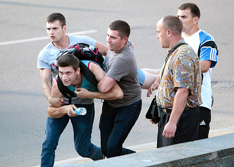 Polizisten tragen einen Demonstranten in Kiew weg