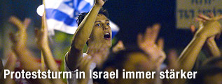 Protestierende Menschen, dahinter Israel-Fahne