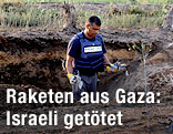Israelische Sicherheitskraft untersucht Bombenkrater