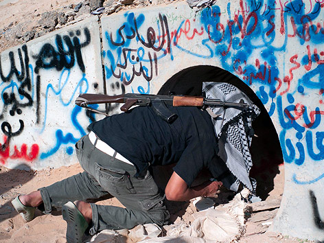 Ein Kämpfer der libyschen Übergangsregierung kriecht in eine Tunnelröhre.