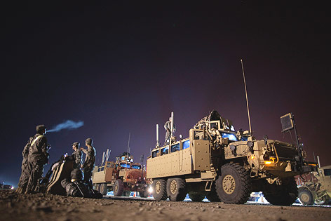 Fahrzeuge und Soldaten der US-Armee sammeln sich nachts zum Abzug