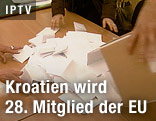 Person leert einen Behälter mit Stimmzetteln aus