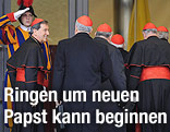 Kardinäle betreten neben Soldaten der Schweizer Garde ein Gebäude