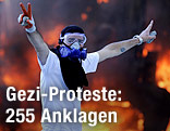 Demonstrant mit Gasmaske vor einem Feuer