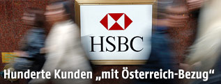 Passanten gehen an einem HSBC-Logo vorbei