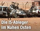Algerischer Soldat vor zerstörten Fahrzeugen
