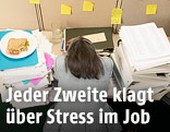 Hinteransicht einer gestressten Frau am Arbeitsplatz