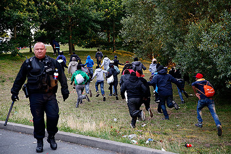 Flüchtlinge und Polizist in Calais, Frankreich