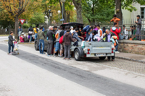 Asylwerber stehen in Traiskirchen neben einem Auto mit Anhänger