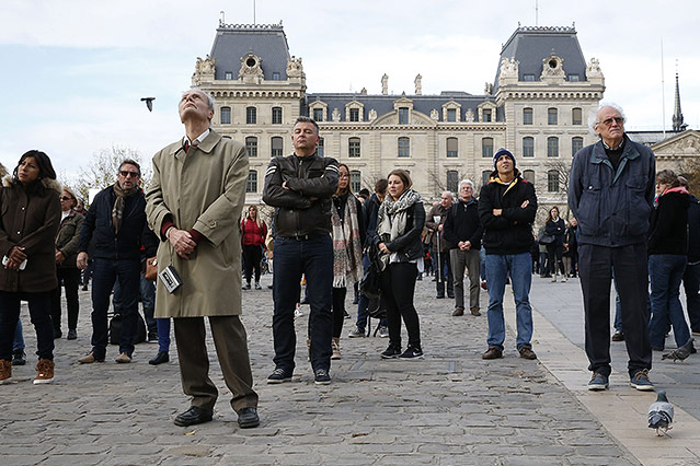Menschen bei einer Gedenkminute am Platz der Notre Dame Kirche 

