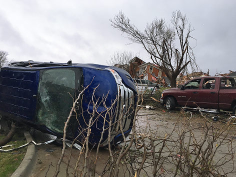 Zerstörtes Haus und umgekippte Autos nach einem Tornado