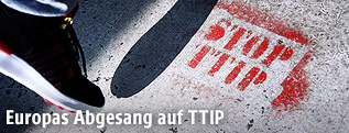 Fuß und ein "Stop TTIP" auf dem Gehsteig